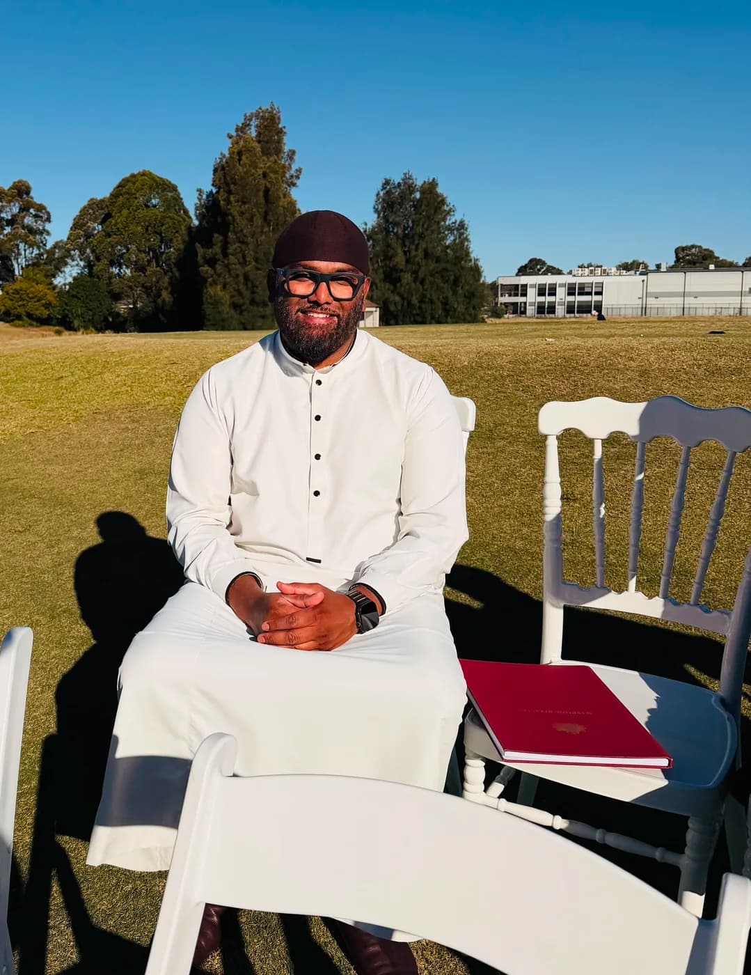 Arshad Khan seated beside the marriage register before an outdoor ceremony