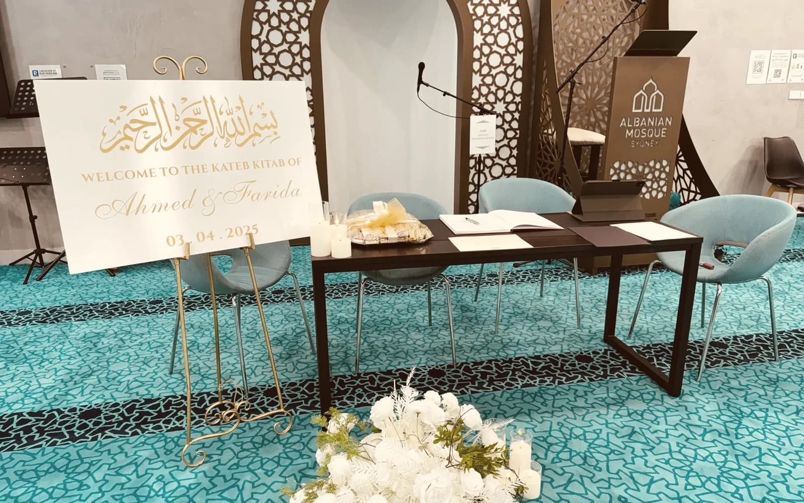 A Nikkah ceremony table set with certificates, candles and the couple's welcome sign